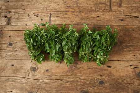 bunch of fresh spearmint on a wooden benchの写真素材