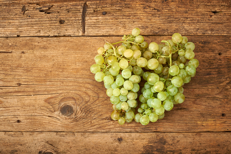 bunch of fresh grapes on a wooden kitchen benchの写真素材