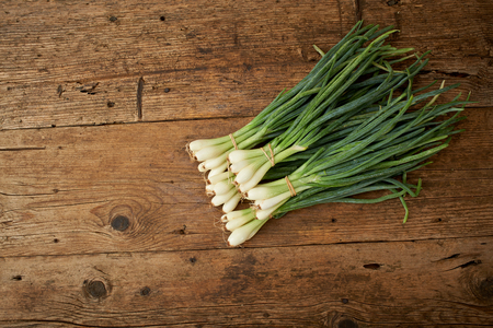 fresh onions on a wooden kitchen tableの写真素材
