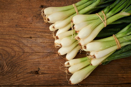fresh onions on a wooden kitchen tableの写真素材