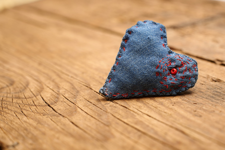 heart made of cloth with red beads on old wood with copy space, concept about love at Christmas, Mother's Day or Valentine's Dayの写真素材