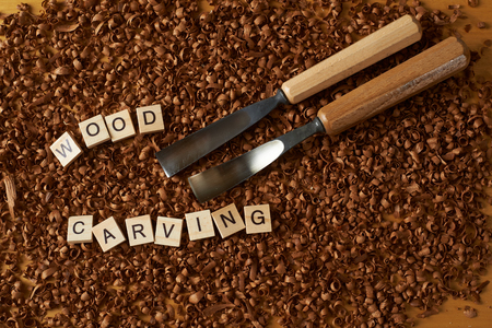 wood carving word writen with letters on wood chips with chiselsの写真素材