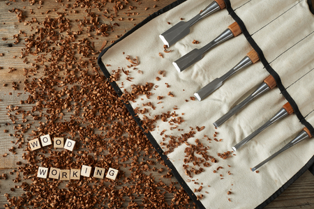 Woodworking word writen with letters on wood chips and chisels, top viewの写真素材