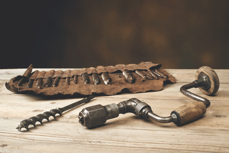 Drill brace with bits in leather tool roll on wooden workbenchの写真素材