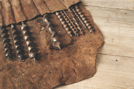Drill bits in leather tool roll on wooden workbenchの写真素材