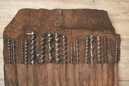Drill bits in leather tool roll on wooden workbenchの写真素材