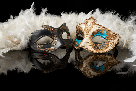 venetian carnival mask with white feathers on black backgroundの写真素材