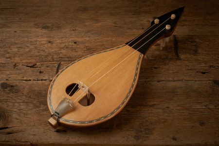 Traditional Greek instrument called Thrakian lyra on wooden backgroundの写真素材