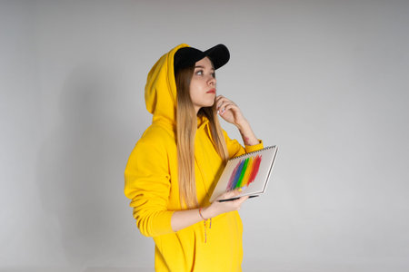 Woman with a notepad on which a rainbow LGBTQ, the girl straightens her hairの写真素材