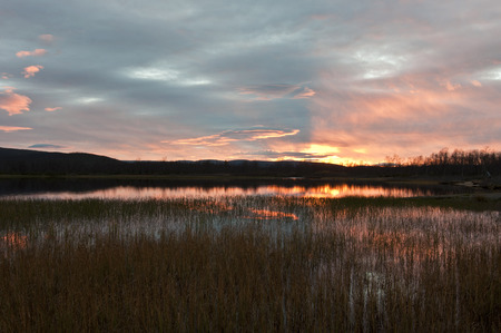 Sunset over the lake, bright autumn sunset over the lakeの写真素材