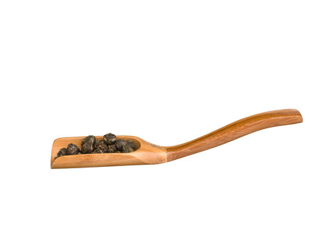 Wooden scoop with dry green tea leaves isolated on white background