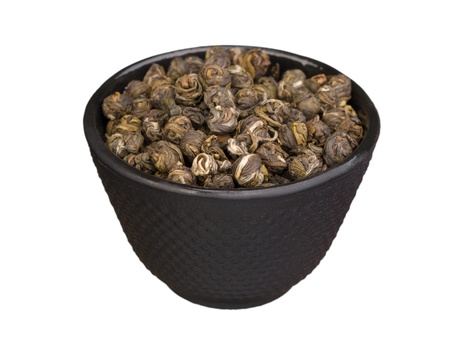 Iron bowl with chinese dry green tea leaves isolated on white backgroundの写真素材