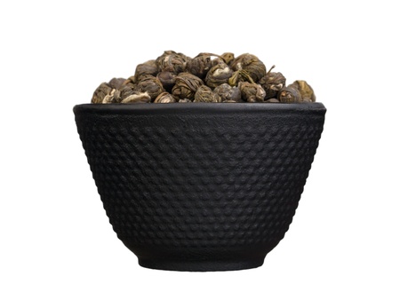 Iron bowl with chinese dry green tea isolated on white backgroundの写真素材