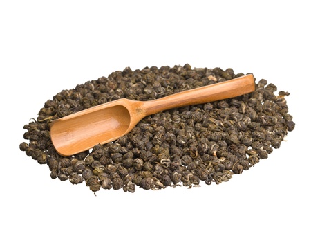 Wooden scoop with chinese dragon pearl jasmine green tea isolated on white backgroundの写真素材