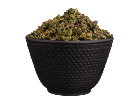 Metal bowl with chinese dry green oolong tea leaves isolated on whiteの写真素材