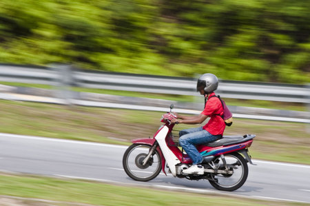 Panning shot of a motorcyclist on a motorcycle with blurred background