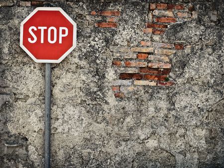 stop sign against grungy wall, may represent protection,dead end,wrong way,resistance...の写真素材