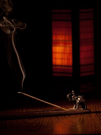 burning incense stick with the oriental style lamp in the background,low keyの写真素材