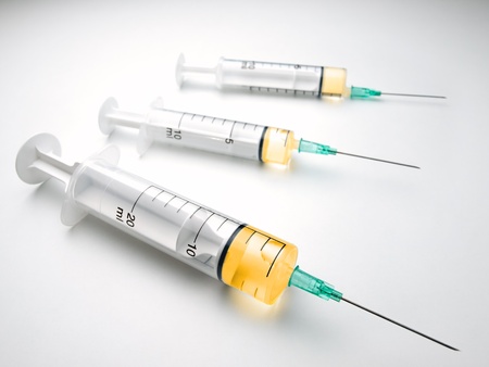 syringes over white surface, for medical,healthcare or pharmacy themesの写真素材