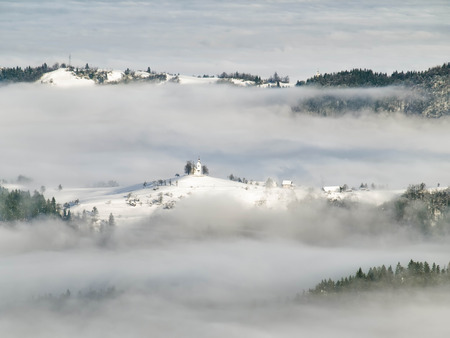 Hills covered with snow and  fog, for weather,winter themes,Slovenia, Europeの写真素材