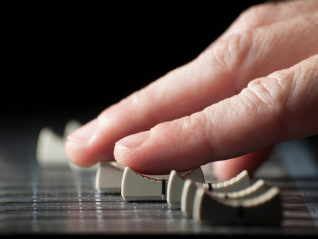 Hand moving  faders of the mixing desk, for music,sound,entertainment themes
