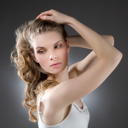 Beautiful blonde woman with arms raised, looking sidewaysの写真素材