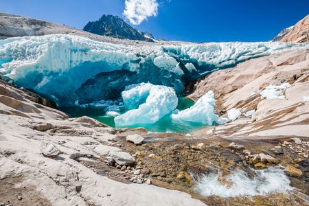 Water flows under the side of Aletsch glacier, which is meltintの写真素材