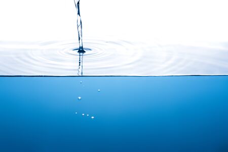 Pure stream touching the surface, few bubbles below the water levelの写真素材