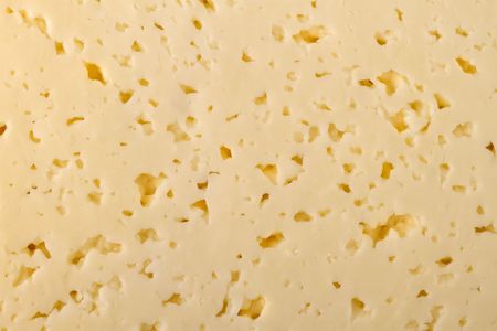 closeup image of some cheese slices with small holes.の写真素材