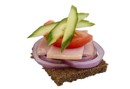 danish open sandwich with onion rings,  ham, tomato and cucumber,  on a dark rye bread. Isolated on a white background.の写真素材
