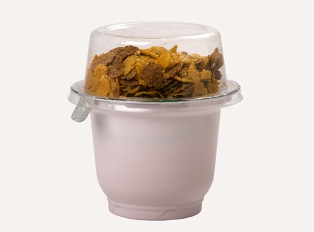 yogurt with corn flakes in a plastic container, isolated on white backgroundの写真素材