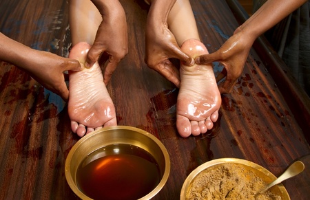   indian doctors doing traditional ayurvedic oil foot massageの写真素材