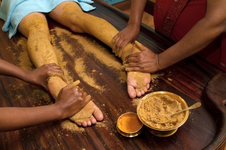   indian doctors doing traditional ayurvedic oil foot massageの写真素材