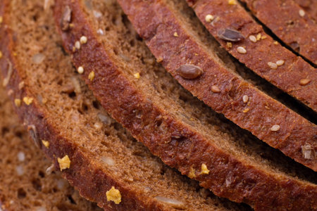 Sliced loaf of fresh rye bread with seeds, close up 