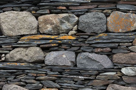 Wall composed of different pieces of basalt covered with lichensの写真素材