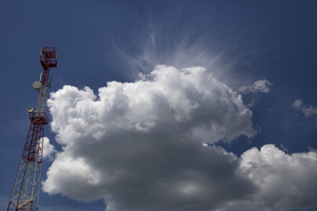 Telecommunication tower, Phone antenna with white cloud and blue sky backgroundの写真素材