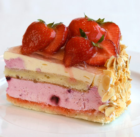 Fresh fruit cake with strawberries and sliced nuts. Close up view.