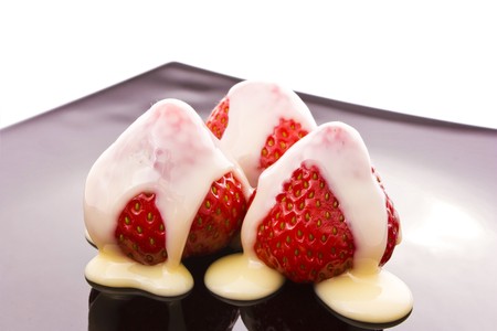 red strawberry on black plate isolated on white の写真素材