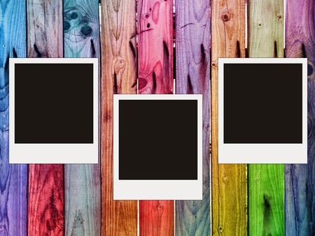 colorful wooden fence with three blank photosの写真素材