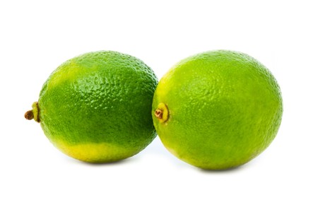 two green fresh limes isolated over whiteの写真素材