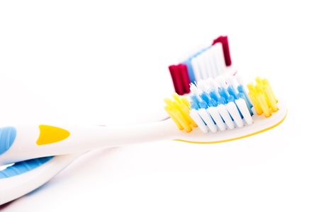 red and yellow toothbrushes isolated on white の写真素材