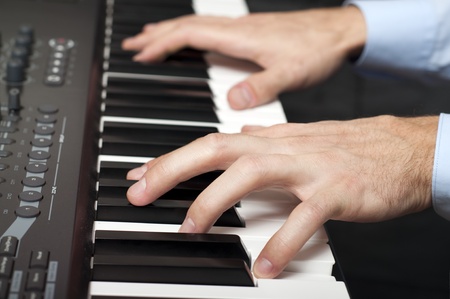 closeup shot of male hands playing the piano in the studio の写真素材