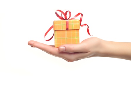female hand holding red and yellow gift box with a bow isolated on white background の写真素材