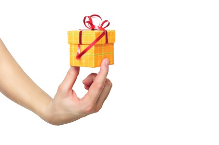 female hand holding red and yellow gift box with a bow isolated on white background の写真素材