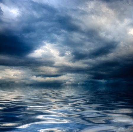 dark cloudy stormy sky with clouds and waves in the sea - global warming concept の写真素材