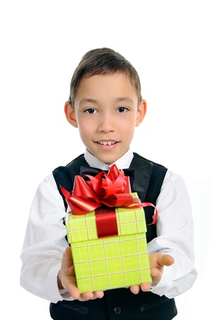 smiling boy in black suit holding green gift box with red bow isolated on white background の写真素材