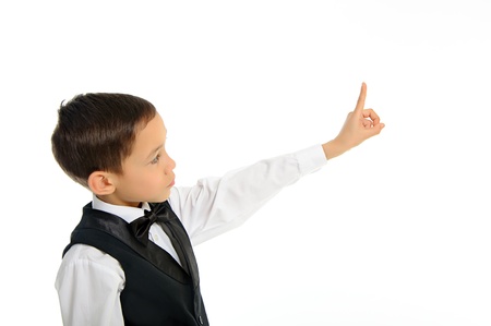 	Portrait of a young school boy in black suit touching something with his finger isolated on whiteの写真素材