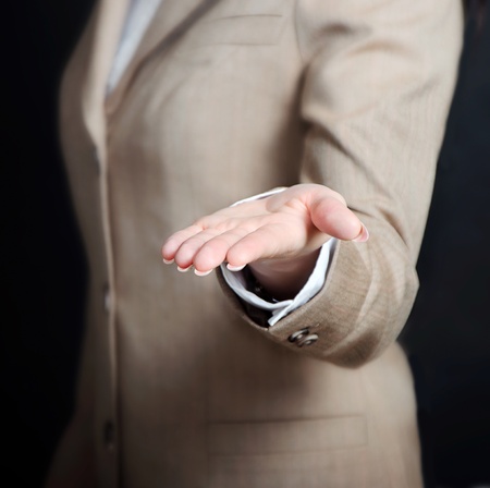 female hand holding showing or giving something over black backgroundの写真素材