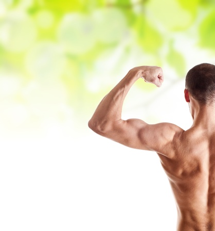 man showing his biceps over green spring healthcare background の写真素材