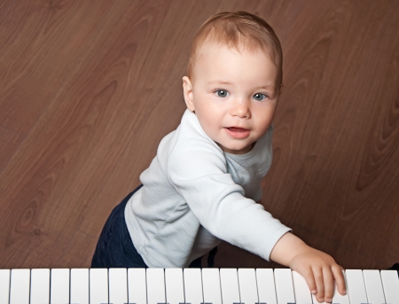 portrait of little baby child  play music on black and white piano keyboardの写真素材